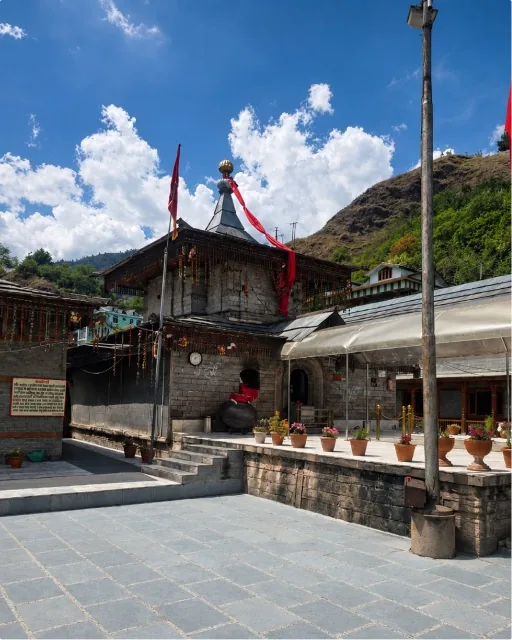 Stone temple with prayer flags in a Himalayan village courtyard